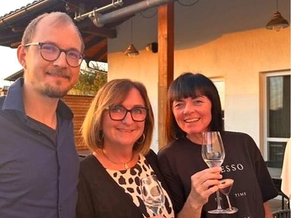 Drei Gäste stoßen auf der Terrasse an